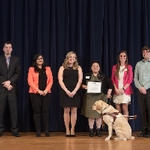 GSA E-board standing on stage with a faculty award receipeint and her service dog
